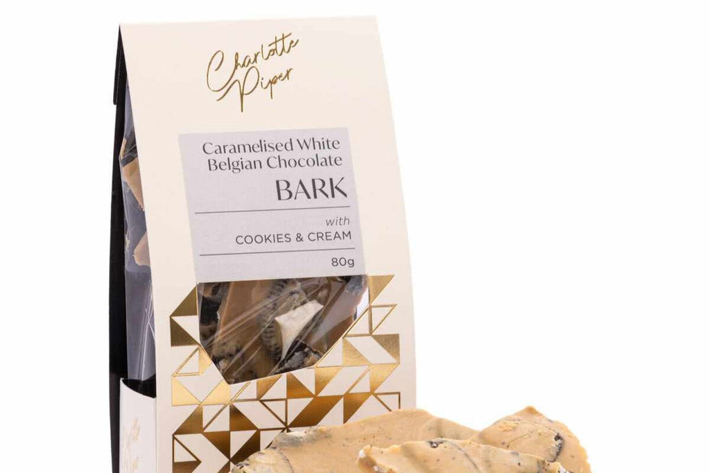 Elegant packaging of Charlotte Piper Caramelised Chocolate Bark, showcasing rich chocolate with a glossy finish and a sprinkle of sea salt, highlighting its crunchy caramelized texture. Perfect for gifting or indulging in a sweet treat.