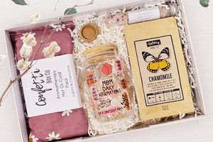 Mom's Rest and Relax Box: The perfect gift for relaxation, featuring an aromatherapy heat pack, chamomile tea, bath salts, a clay facial mask, and an affirmation tumbler for mothers. Presented with exclusive confetti and a beautiful bow for a thoughtful and serene experience.