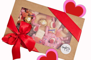 Valentine’s Sweet Treat Box featuring 4 Krispy Kreme donuts topped with KitKat Minis, white TimTams, sour heart lollies, mini musk sticks, strawberries & cream Allens lollies, Mentos, and Ferrero Rocher chocolates, presented in a 25x16x8 cm gift box.