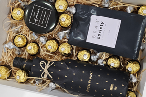 Posh Plonk Shiraz Gift Box: Perfect for relaxation, this luxurious set includes a 750ml bottle of Posh Plonk Shiraz, Soak Society Wellness Soak, an aromatic candle, Ferrero Rocher chocolates, and Hershey's Kisses. Finished with signature confetti, a beautiful bow, and a personalized message card for a thoughtful gift.