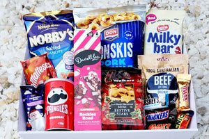 A festive Christmas treat box filled with an assortment of holiday snacks, including Nobby's nuts, Milky Bar chocolate, Darrell Lea sweets, Pringles, and Maltesers, all beautifully packaged for a joyful seasonal celebration.
