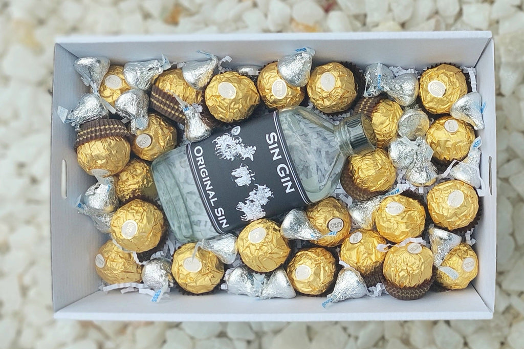 A delightful Gin and Kisses gift box featuring a 200ml bottle of Sin Gin Original Sin, 15 Ferrero Rocher chocolates, and a selection of Hershey's Kisses, all elegantly presented with a complimentary personalized message for a thoughtful and indulgent gift.
