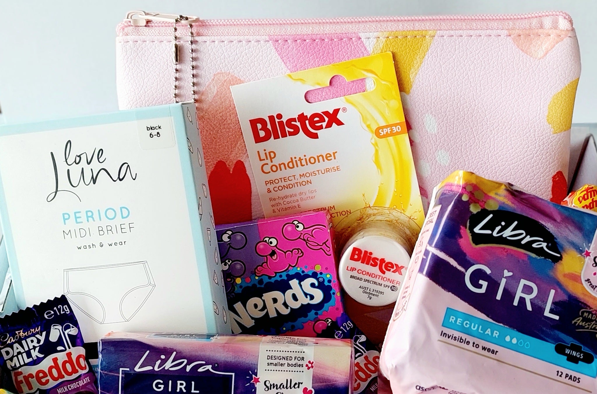 First Time Period Box: A thoughtful and supportive gift for young girls transitioning into womanhood. Includes Libra pads, tampons, Love Luna period briefs (sizes 6-8, 8-10, 12-14), lip balm, Nerds candy, Chupa Chups lollipops, Freddo Frog chocolates, assorted lollies, and an organized case. Beautifully wrapped with abundant confetti for a special and comforting touch.